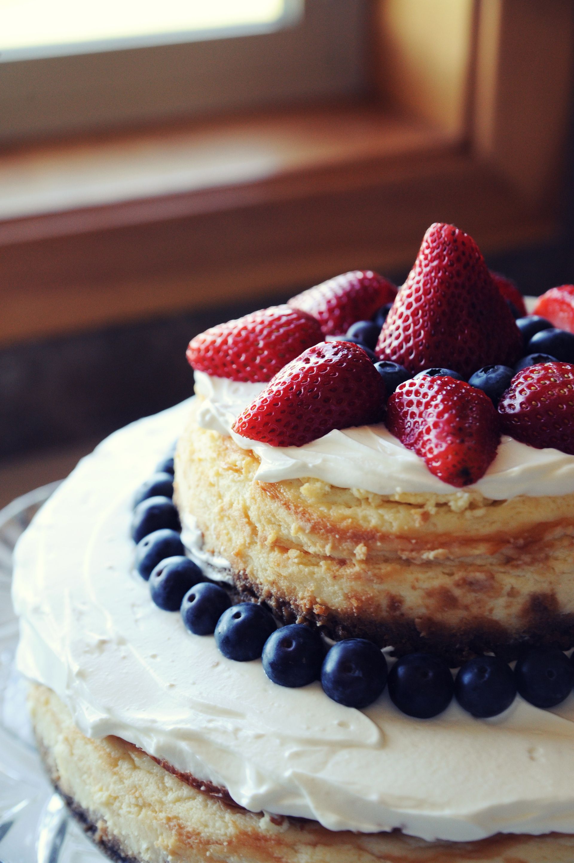 A cake with berries and cream on top.