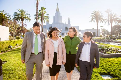 a family spends time together on the grounds in front of the Oakland California Temple