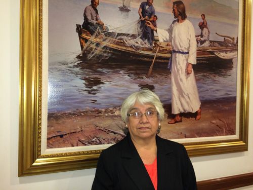 woman standing in front of painting of Jesus Christ