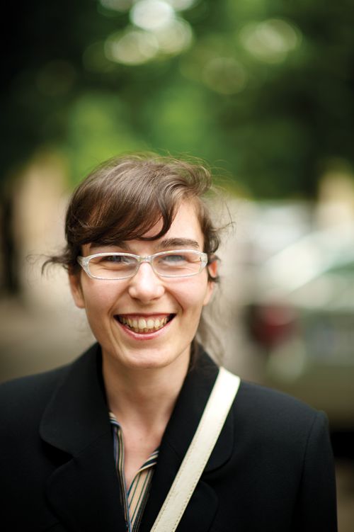 Portrait of an adult female with glasses, smiling.