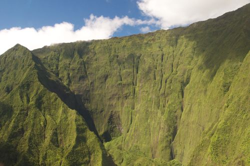 Cliffs on the island of Hawaii with a blue sky and clouds above.