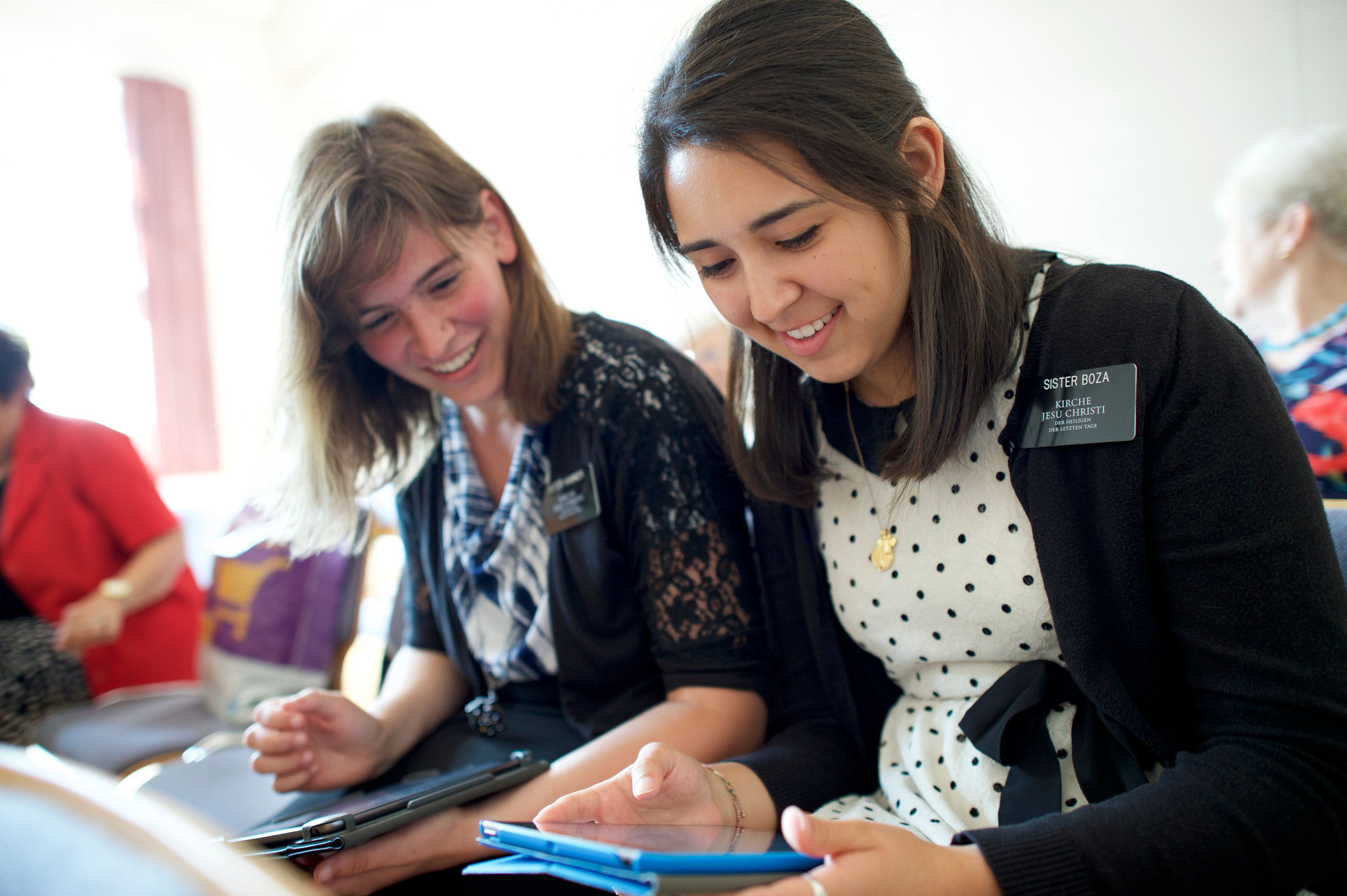 Two sister missionaries in Germany sit and study together on their tablets.