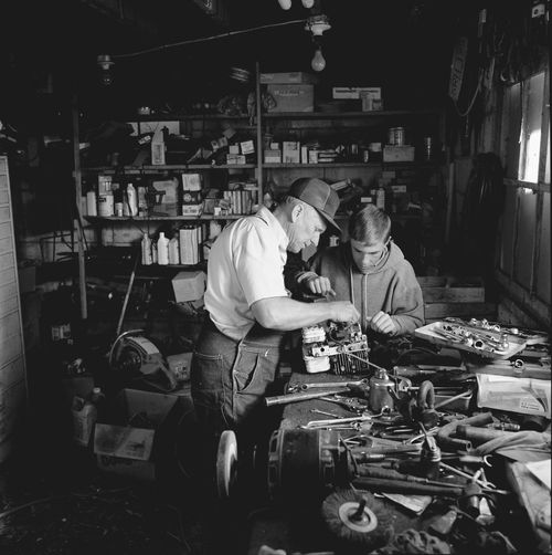 father and son fixing engine