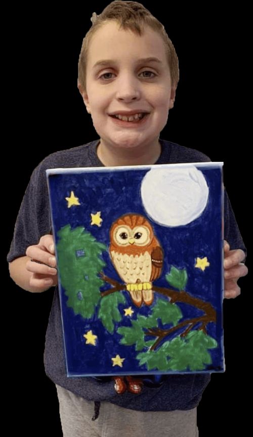 Boy holding painting of owl