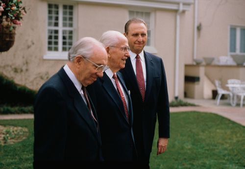 President Benson standing outside between President Monson and President Hinckley, all three in black suits, white shirts, and red ties.