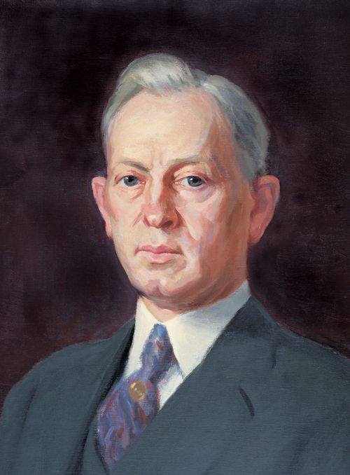 A portrait painting of the prophet Joseph Fielding Smith in a white shirt, dark suit, and purple tie.