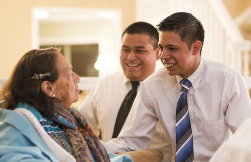 two young men talking to woman