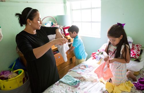 une mère et ses enfants pliant du linge