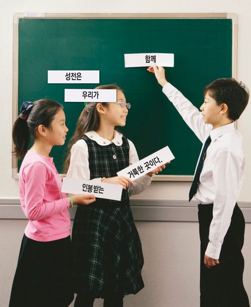 Primary children holding up word strips