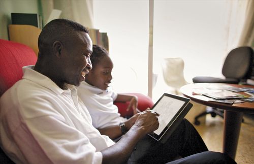 father and his son looking at a tablet