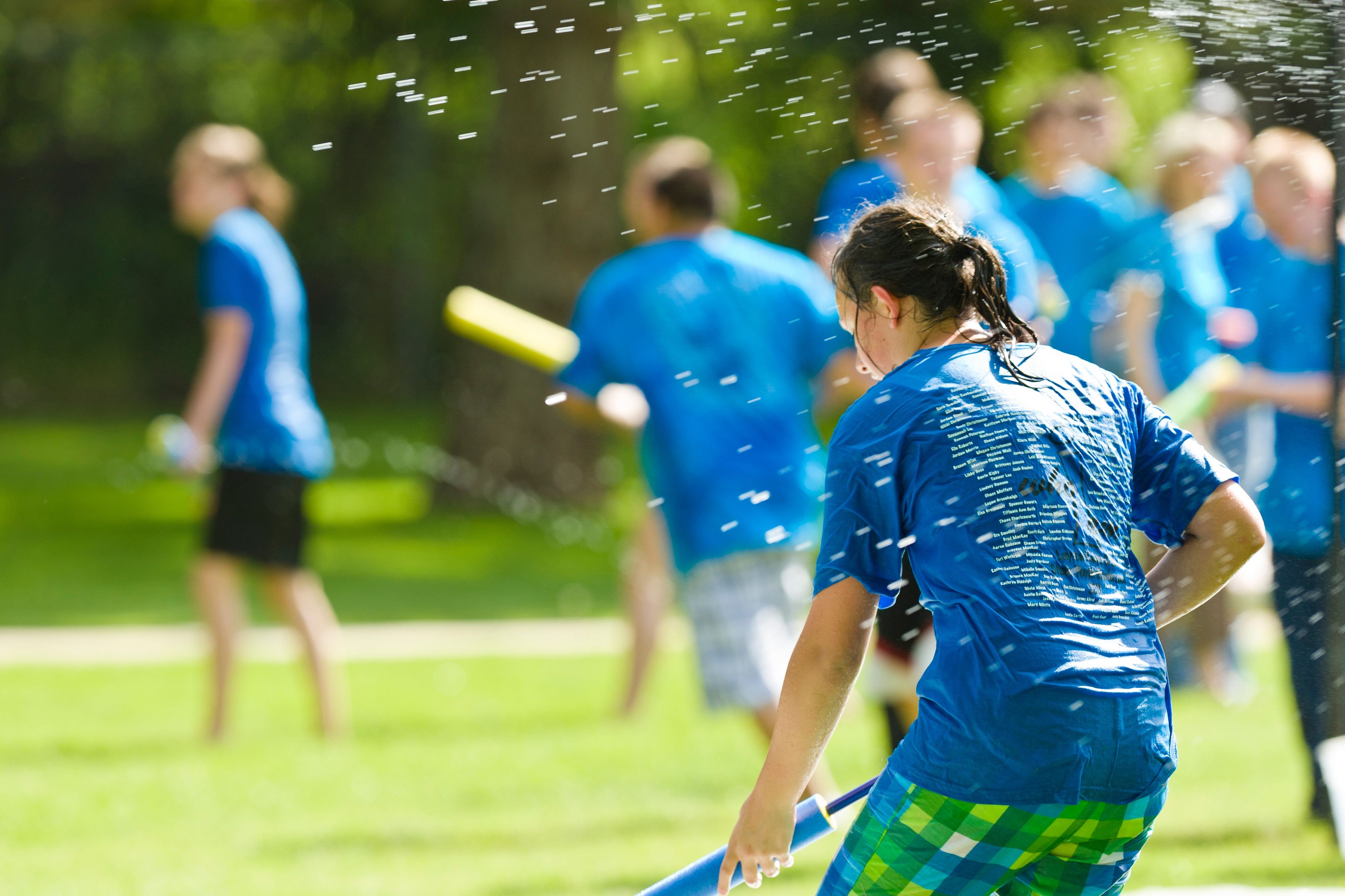 A group of youth play water games outside.  