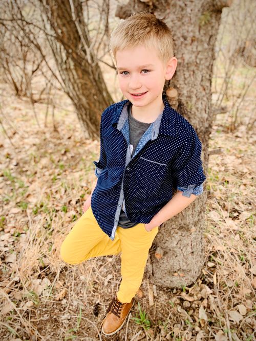 A Young Boy named Drake standing next to a tree