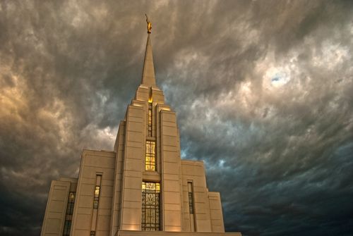 The front of the Rexburg Idaho Temple, with storm clouds above the spire.