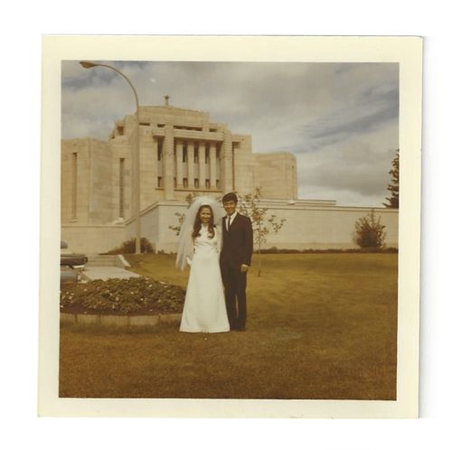 a couple on their wedding day standing in front of the Cardston Alberta Temple