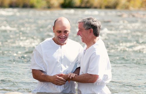湖でバプテスマを施す男性