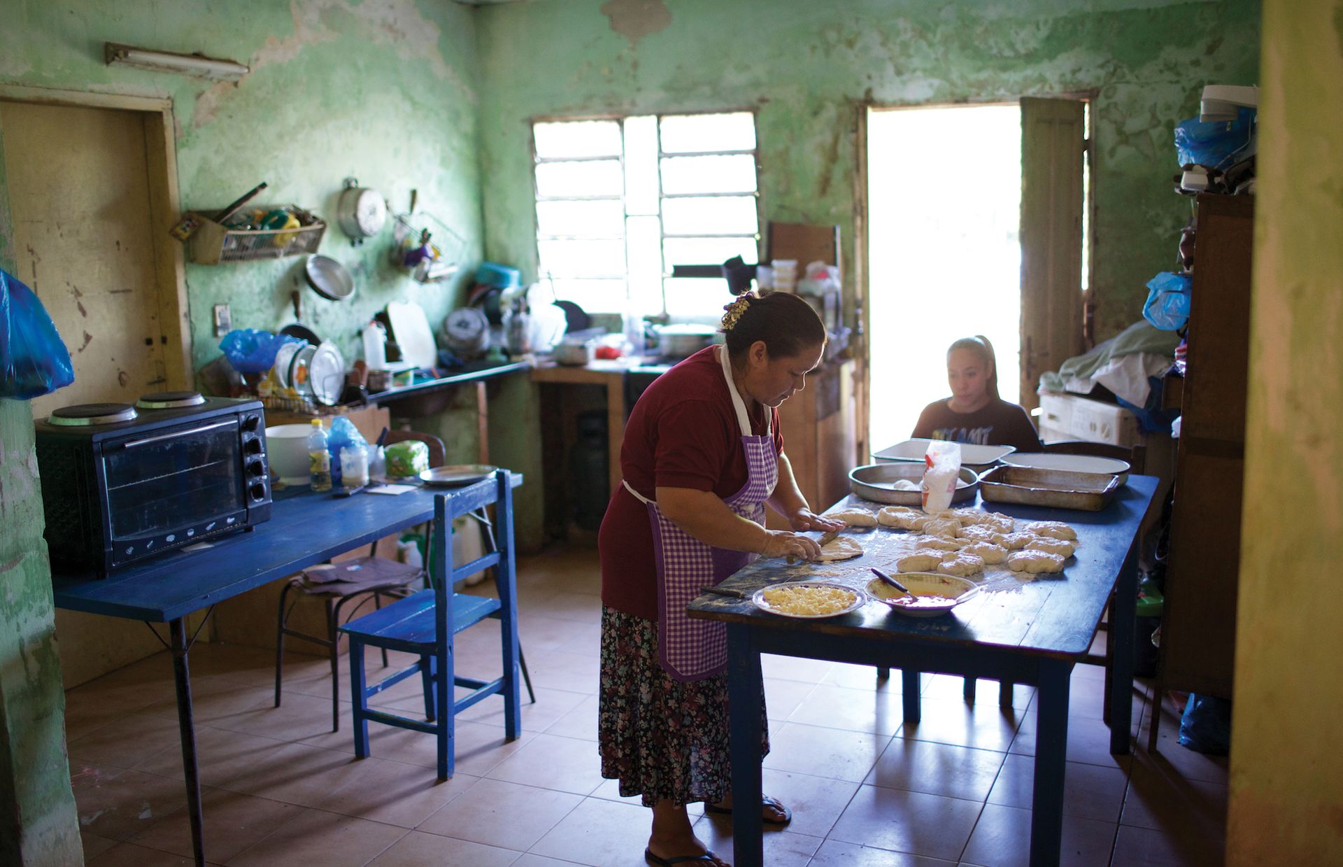 The day begins early for Adriana as she prepares dough for the bread she will bake and sell. All day long the kitchen table serves as a gathering place for the González family.
