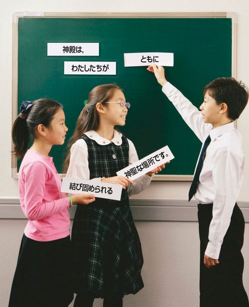 Primary children holding up word strips