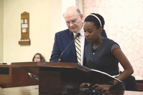 Young adult standing next to Elder Renlund