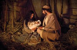 Mary and Joseph hold the newborn baby Jesus in a stable at Bethlehem