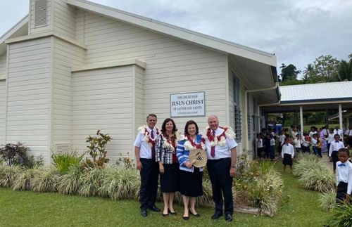 Si Elder Rasband, ang kanyang asawa, at iba pa sa labas ng isang meetinghouse sa Fiji