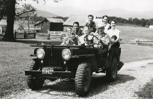 President Ezra Taft Benson driving a vehicle with his wife Sister Flora Smith Amussen Benson, and their six children riding with him.