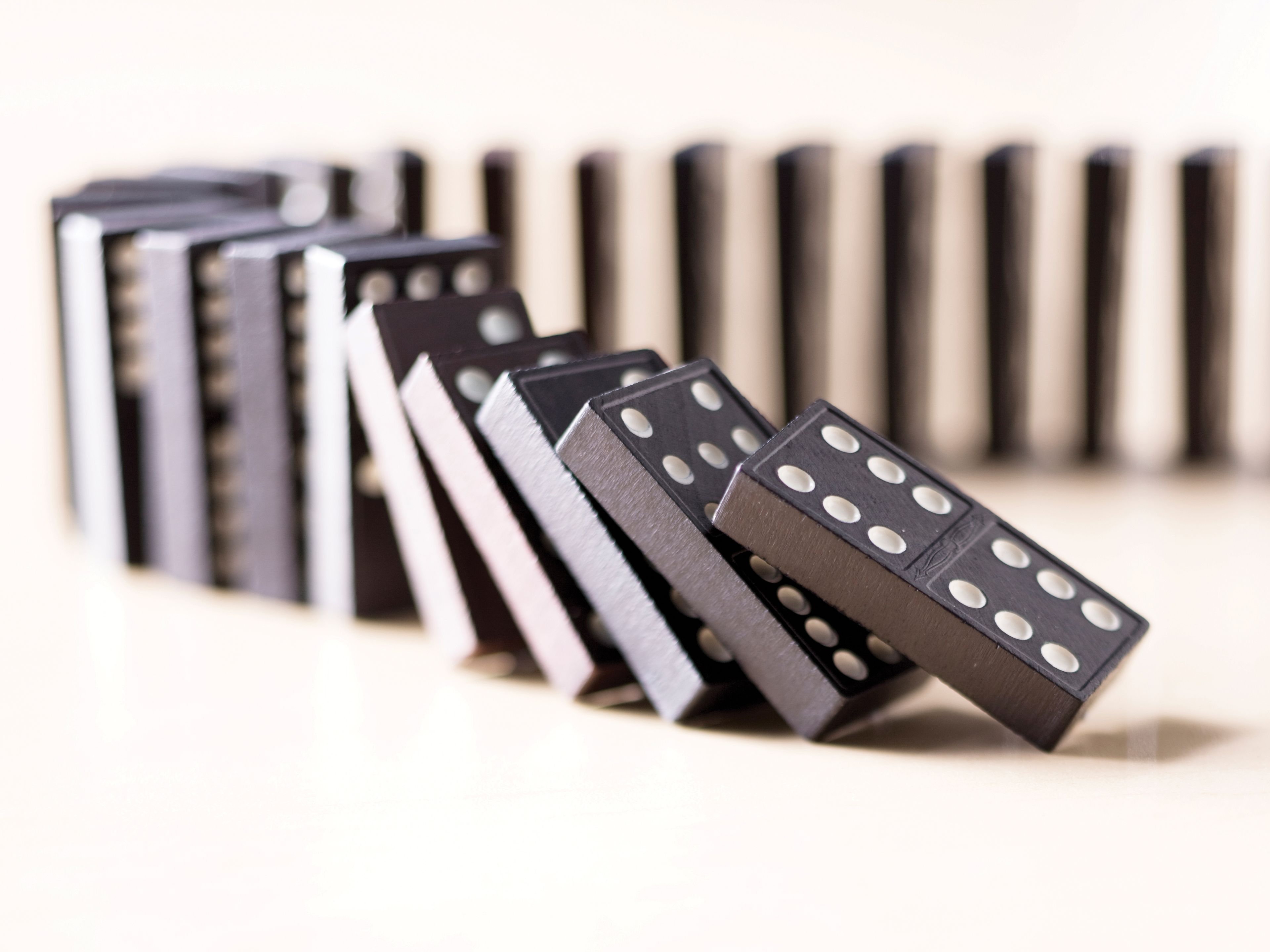 A row of dominoes tipping over in succession.
