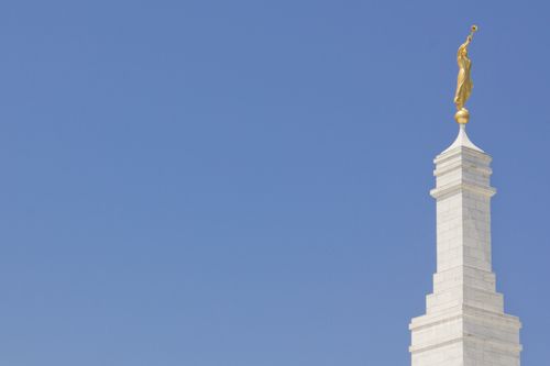 The spire and angel Moroni on top of the Columbia South Carolina Temple, with a blue sky in the background.