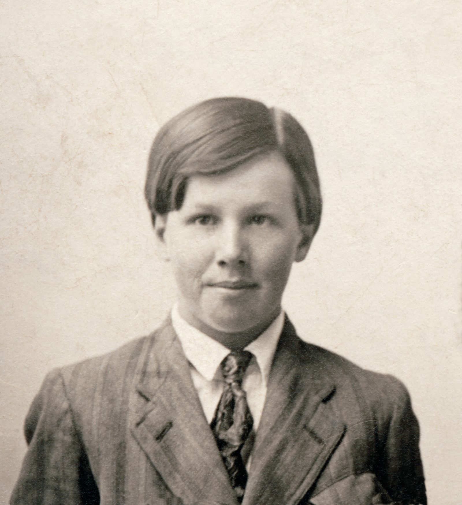 President Benson as a young man with his hair parted, wearing a suit and tie.