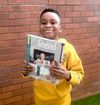 Boy holding a copy of the Friend