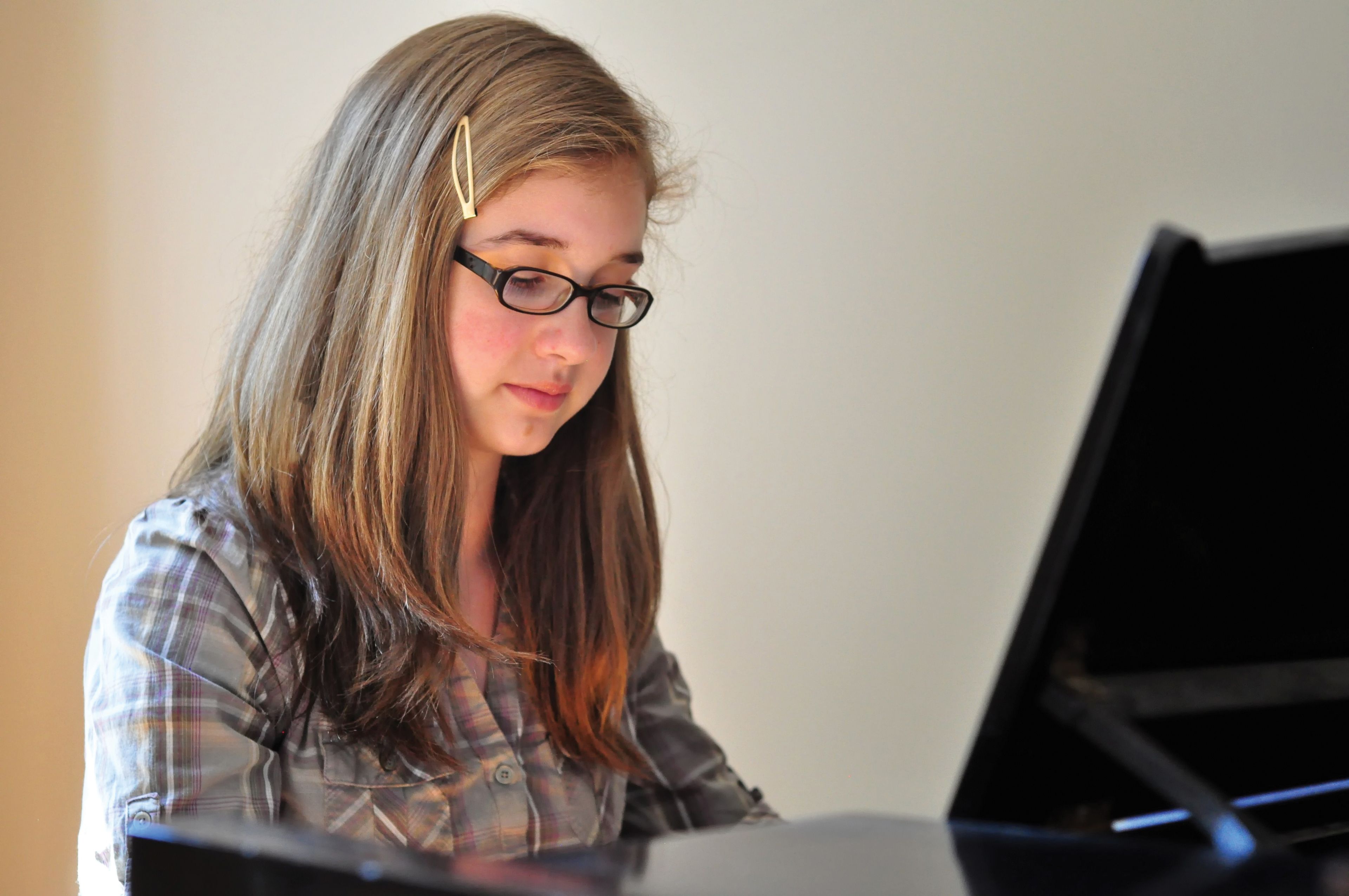 A young woman plays the piano.
