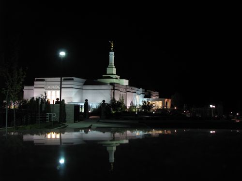The entire Reno Nevada Temple lit up at night, with a view of the reflecting pond and the grounds around the temple.