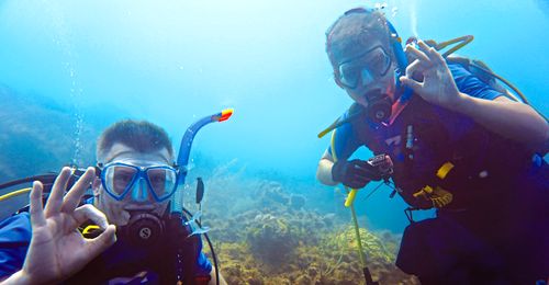 young man and father scuba diving