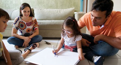 Una joven colorea con su familia