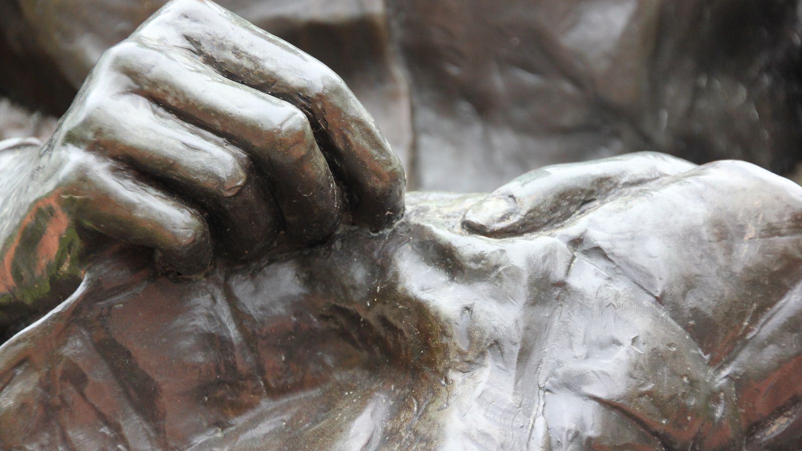 A bronze statue depicting a woman quilting.