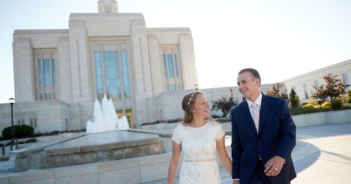 Young couple walks near water fountain as the leave the Ogden Utah Temple.