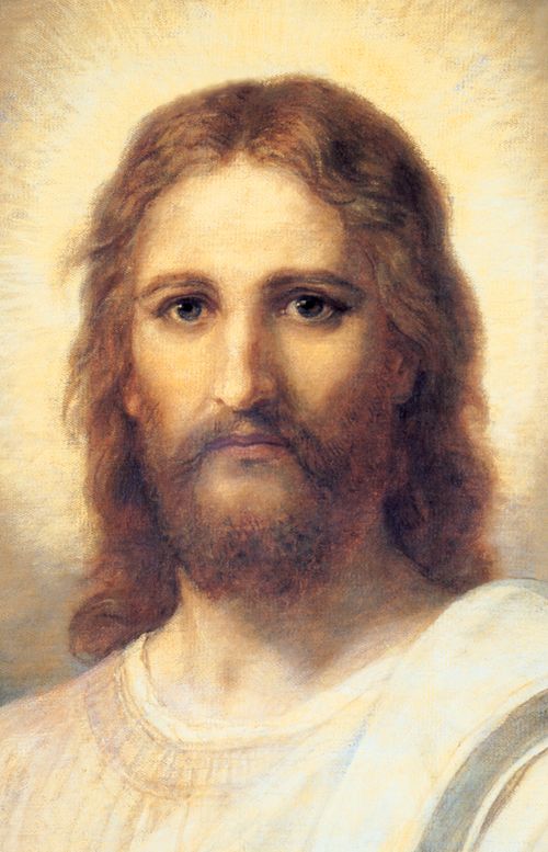 Frontal head and shoulders portrait of Jesus Christ. Christ is depicted wearing a pale red robe with a white and blue shawl over one shoulder. Light emanates from His face.