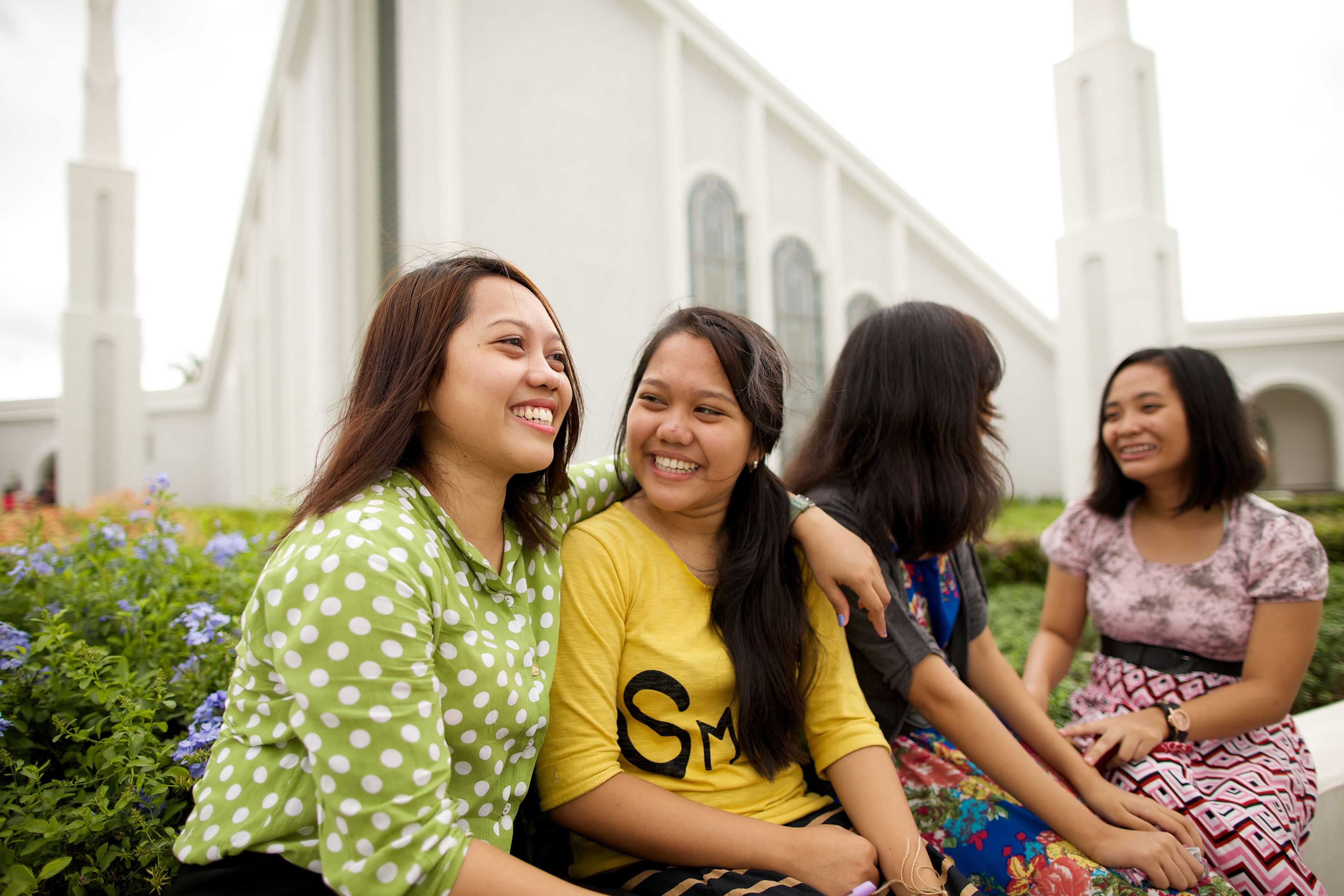Four young women sitting outside the temple.