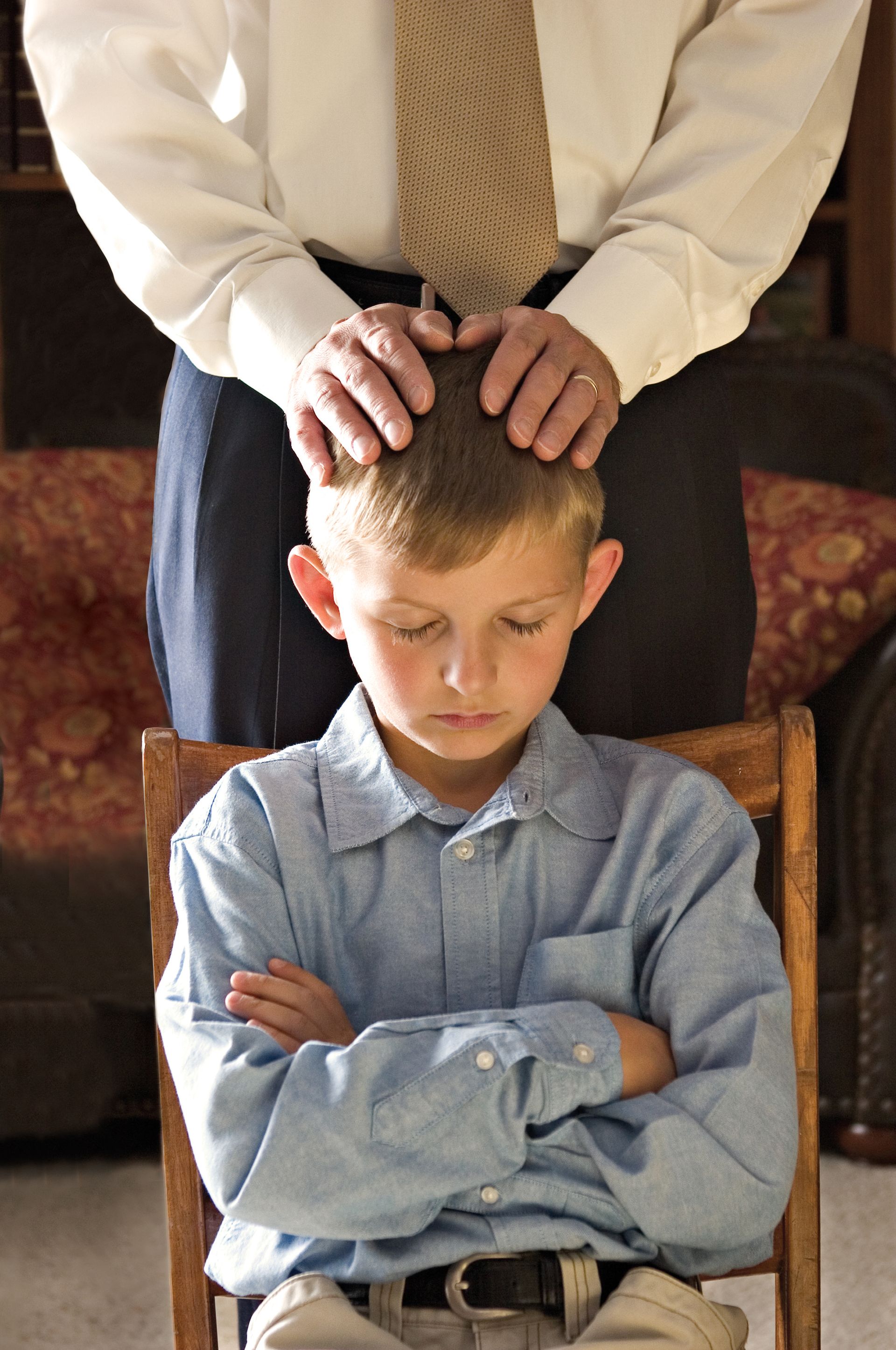A father gives his son a priesthood blessing.