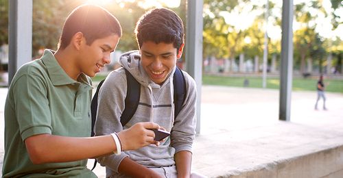 A young man showing something on his smartphone to another young man.