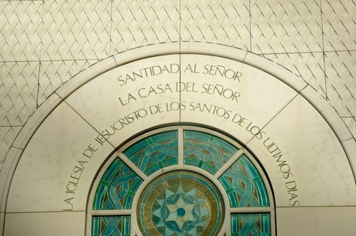 A close-up of a stained-glass window and an inscription that reads, “Holiness to the Lord: The House of the Lord” in Spanish on the exterior of the Madrid Spain Temple.