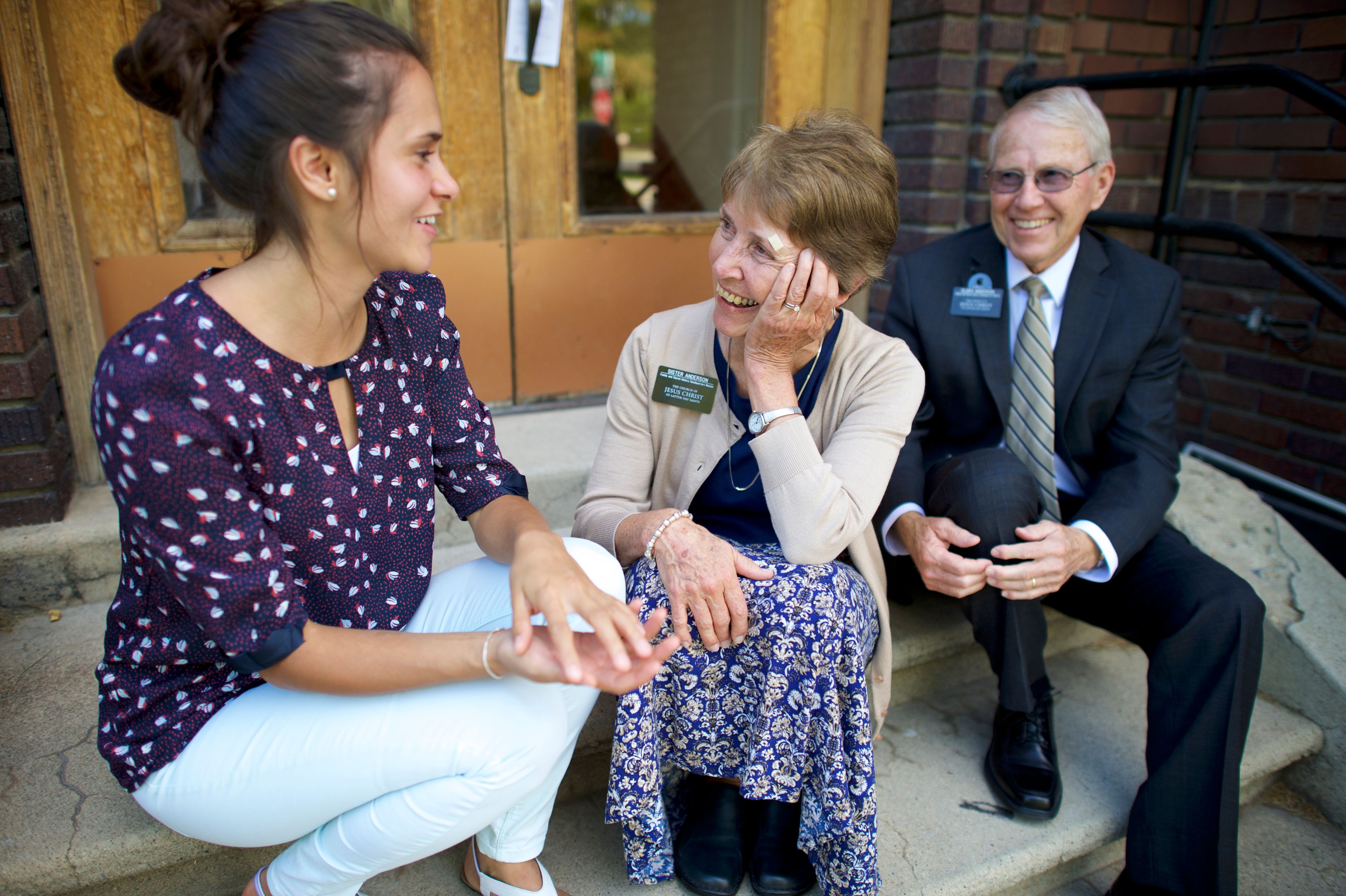 A senior missionary couple sitting and talking with a woman.