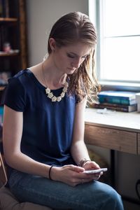 youth reading scriptures on a phone