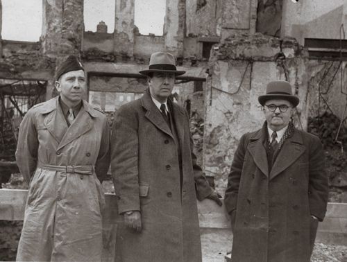 Elder Benson around 1946, standing with two missionary companions in long coats and hats in Europe.