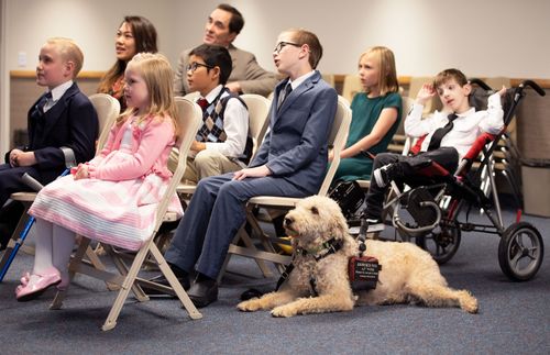 a group of children in Primary; one has a service dog, and another is in a stroller