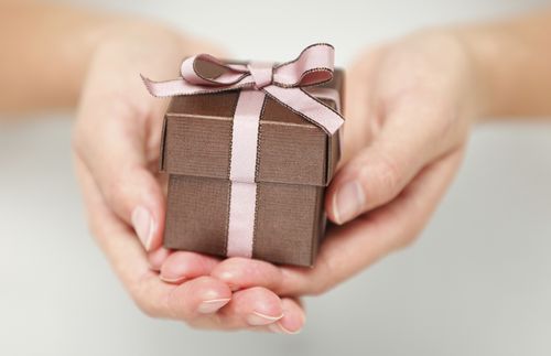 Photo of a small gift box cradled in a woman's hands.