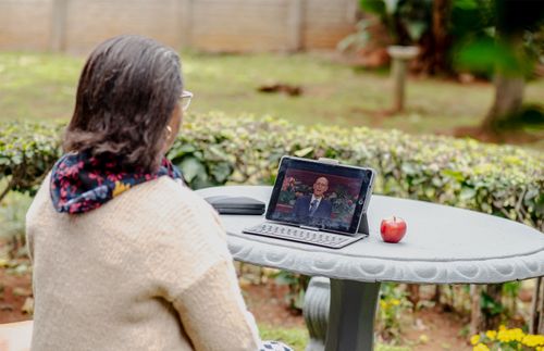 uma mulher assistindo a conferência geral em um tablet