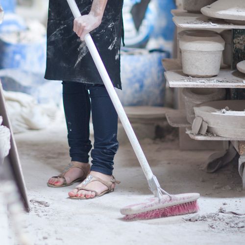 girl with broom sweeping floor