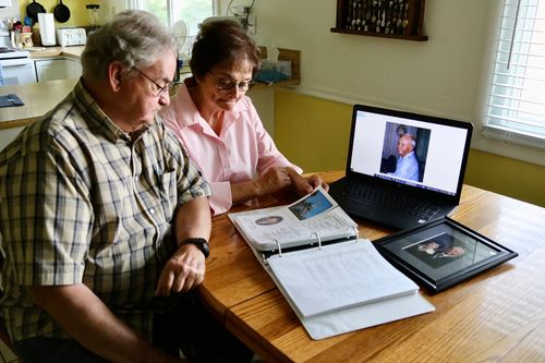 husband and wife looking at book