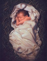 blanketed infant laid in hay