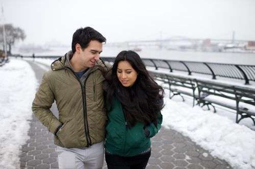 Ein junges Paar geht im Schnee spazieren